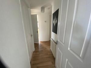 a hallway with a white door and a wooden floor at Paddock View - Snetterton Norfolk in Norwich