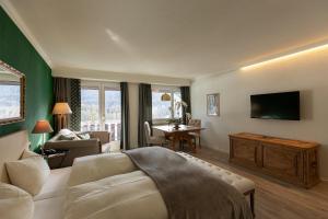 a hotel room with a bed and a living room at Hotel Europa Suites St Moritz in St. Moritz