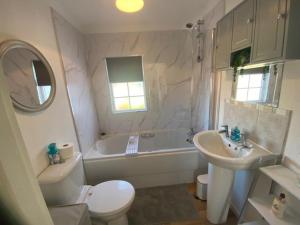 a bathroom with a tub and a sink and a toilet at Paddock View - Snetterton Norfolk in Norwich