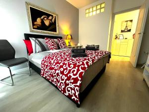 Un dormitorio con una cama roja y blanca con una silla. en Host Flora Sanremo, en San Remo