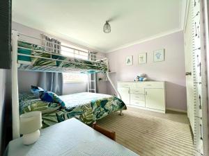 Un dormitorio con dos literas y un escritorio. en Tuncurry tranquility PID -STRA - 59456, en Tuncurry