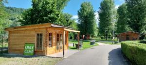 a small building with a sign in a park at Camping Onlycamp Les Adoubes - Albertville in Albertville