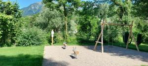 a park with a playground with a wooden pole at Camping Onlycamp Les Adoubes - Albertville in Albertville