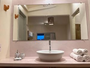 a sink in a bathroom with a large mirror at Flat's Maravista Beiramar in São Miguel do Gostoso +10 photos