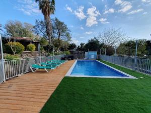a swimming pool with lounge chairs and a fence at מול הנוף ברמות in Moshav Ramot