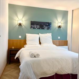 クルブヴォアにあるCosy Appartement 2P avec Balcon Paris La Défense Parking Gratuitのベッドとタオル2枚のある寝室