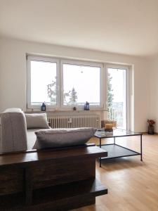 a living room with a couch and two windows at Wohnen bei Franzi - Tolle Wohnung für 4 Personen in Altötting