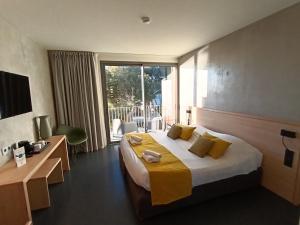 セットにあるDomaine du Lazaret - Village vacances 3 étoiles en bord de merのベッドと大きな窓があるホテルの部屋