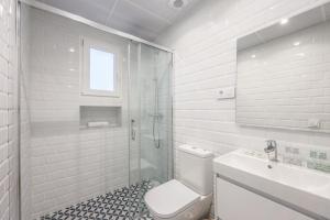 une salle de bain blanche avec toilettes et lavabo dans l'établissement Urban Tranquility in Madrid with Modern Comforts, à Madrid