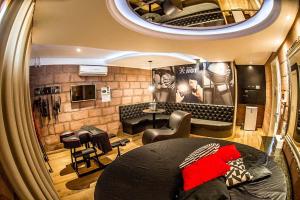 a bedroom with a bed and a living room at Motel Paradiso - Ibirubá-RS in Ibirubá