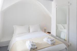 a white bedroom with a bed with towels on it at Coco-Mat Eco Residences Serifos in Vayiá