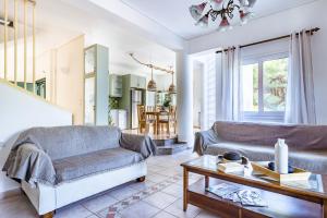 a living room with two couches and a table at Nature Grand Estate in Skopelos Town
