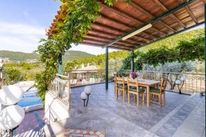 an outdoor patio with a table and chairs and a pool at Nature Grand Estate in Skopelos Town