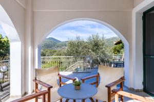 a patio with a table and chairs on a balcony at Nature Grand Estate - Spacious Villa with Pool in Skopelos Town