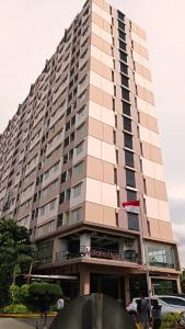a tall building with a flag on it at Mountain View at The Edge in Cimindi