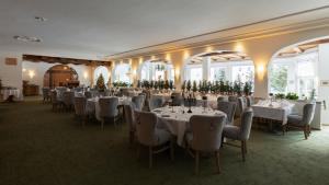 a banquet hall with tables and chairs and windows at Hotel Europa Suites St Moritz in St. Moritz
