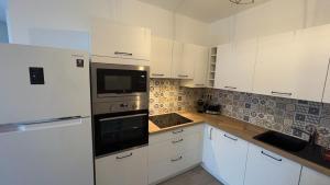 a kitchen with white cabinets and a stove top oven at Magnifique 2p cœur historique in Auray +6 photos
