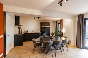 a kitchen and dining room with a table and chairs at Boerderijkamer Zonlicht in Lutten