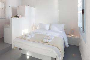 a white bedroom with a bed with towels on it at Coco-Mat Eco Residences Serifos in Vayiá