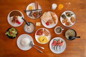 a wooden table with plates of food on it at Kokotel Khao Lak Isara Casa in Khao Lak