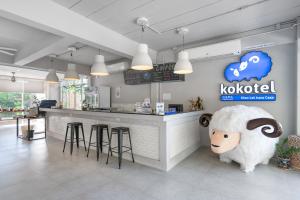 a restaurant with a counter with a bar with a sheep mascot at Kokotel Khao Lak Isara Casa in Khao Lak