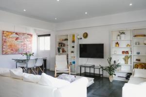 un soggiorno con mobili bianchi e TV a schermo piatto di Cathedral - City Center - Free Parking - Climatized a Almería