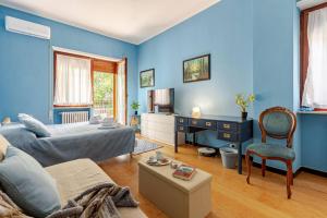 a bedroom with blue walls and a bed and a couch at CASA LORY Balduina in Rome
