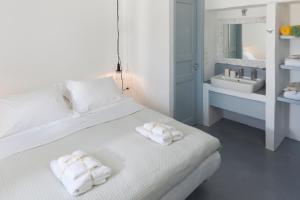 a white bedroom with a bed with towels on it at Coco-Mat Eco Residences Serifos in Vayiá