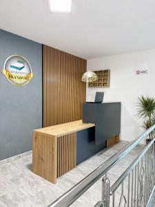 an office with a desk and a sign on the wall at Apartmani Ikanović in Cazin