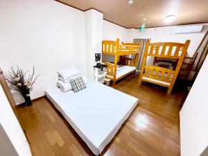 Postel nebo postele na pokoji v ubytování PetitHotel017全室ミニキッチン付きファミリルーム 飲食街中心 阿波踊り会館7分 文理 徳島大学 アスティとくしま車8分