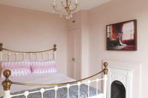 a bedroom with a bed with a fireplace and a chandelier at Stanhope House in Hastings