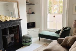 a living room with a fireplace and a green couch at Stanhope House in Hastings