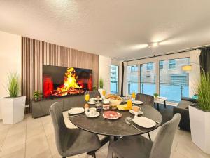 a living room with a table and a fireplace at Auszeit Apartment EMOTION in Friedrichshafen