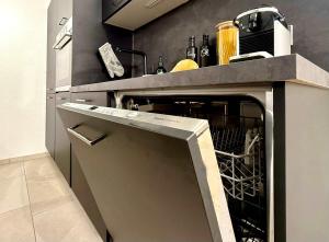 a kitchen with an oven with its door open at Auszeit Apartment EMOTION in Friedrichshafen +18 photos