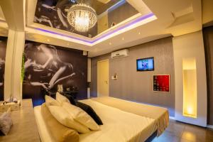 a bedroom with a large bed and a chandelier at Motel Paradiso - Panambi-RS in Tabapira