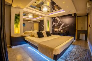 a bedroom with a large bed with lights on it at Motel Paradiso - Panambi-RS in Tabapira