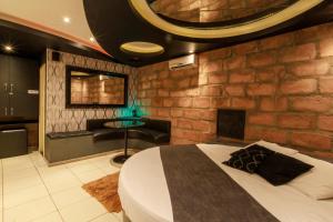 a bedroom with a bed and a brick wall at Motel Paradiso - Panambi-RS in Tabapira