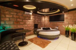 a bedroom with a bed and a tv and a table at Motel Paradiso - Panambi-RS in Tabapira