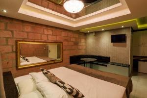 a bedroom with a large bed and a mirror at Motel Paradiso - Panambi-RS in Tabapira
