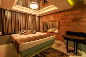 a bedroom with a bed and a table and a piano at Motel Paradiso - Panambi-RS in Tabapira