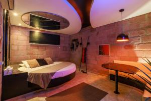 a bedroom with a bed and a desk and a piano at Motel Paradiso - Panambi-RS in Tabapira