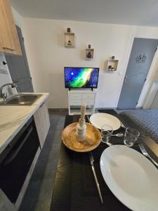 a kitchen with two white sinks and a tv at Cosy Studio Confort in Étampes-sur-Marne