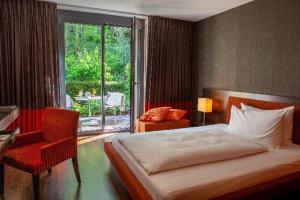 una camera da letto con un letto, una scrivania e una finestra di Bad Bubendorf Design & Lifestyle Hotel a Bubendorf