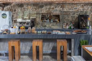 a bar with two chairs and a counter with food at Coco-Mat Eco Residences Serifos in Vayiá