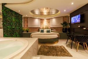 a hotel room with a bed and a bath tub at Motel Paradiso - Panambi-RS in Tabapira