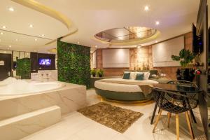a bedroom with a bed and a tub and a sink at Motel Paradiso - Panambi-RS in Tabapira