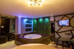 a bathroom with a tub and a tv in a room at Motel Paradiso - Panambi-RS in Tabapira