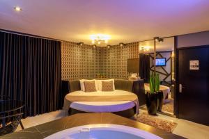 a bedroom with a bed and a tub in a room at Motel Paradiso - Panambi-RS in Tabapira