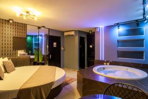 a room with a large bed with a tub in it at Motel Paradiso - Panambi-RS in Tabapira
