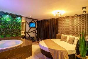 a bedroom with a bath tub and a bed and a bath tub at Motel Paradiso - Panambi-RS in Tabapira
